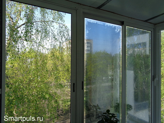 Застекленный балкон с солнцезащитной пленкой, наклеенной на стекло