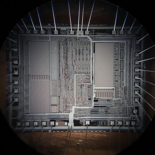 Увеличение 20x. Советский процессор с электрическим программированием и ультрафиолетовым стиранием 1816ВЕ48 (аналог intel 8748). Процессоры изготовлялись с прозрачным окошком для ультрафиолета, через которое и был сделан этот снимок.