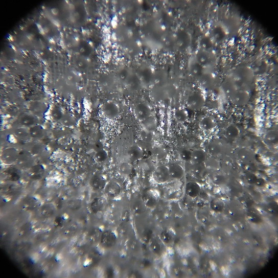 Учебный микроскоп УМ-401П. Увеличение 80x. Светоотражающая лента, применяемая на спецодежде дорожно-строительных рабочих и работников ЖКХ. Видно, что она состоит из стеклянных микрогранул, нанесённых на зеркальную поверхность.