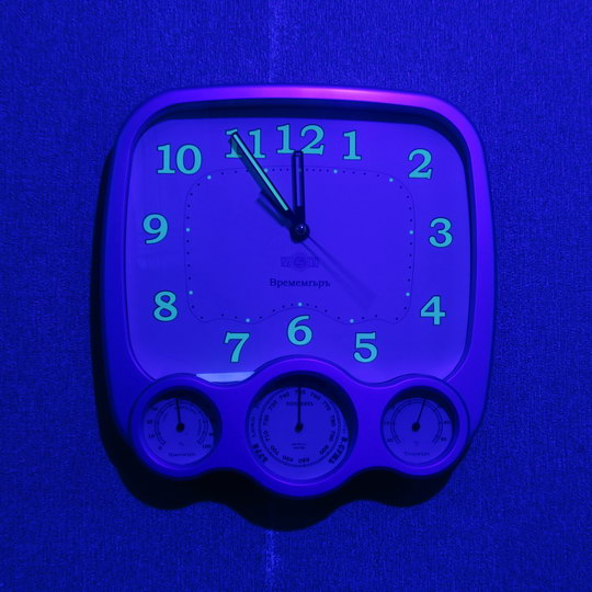 настенные часы с цифрами, выполненными люминофором, в ультрафиолетовом свете